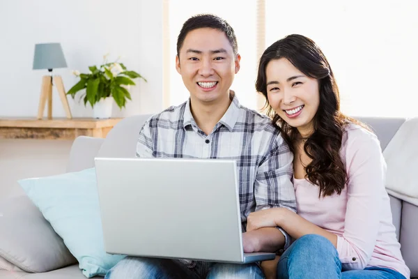 Sorrindo jovem casal usando laptop — Fotografia de Stock