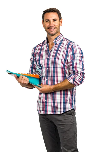 Smiling man standing while holding notepads — Stock Photo, Image