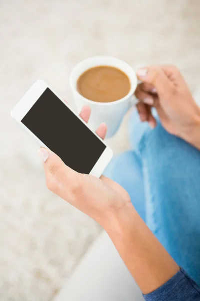 Mujer sosteniendo café y teléfono inteligente —  Fotos de Stock