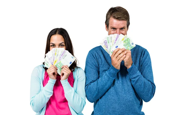 Retrato de casal escondendo rosto com dinheiro — Fotografia de Stock