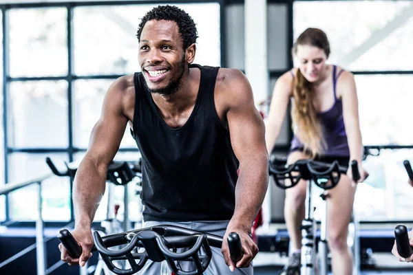 Hombre en forma haciendo ejercicio en la clase de spinning —  Fotos de Stock