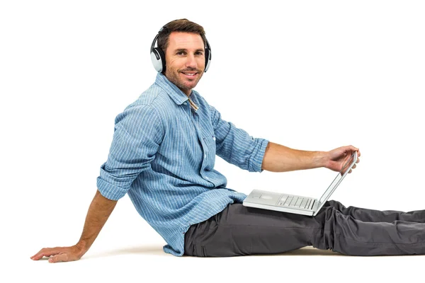 Hombre feliz sentado en el suelo usando el ordenador portátil —  Fotos de Stock