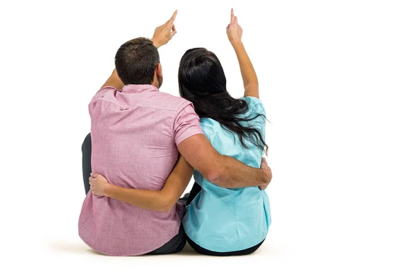 Couple sitting and pointing somewhere — Stock Photo, Image