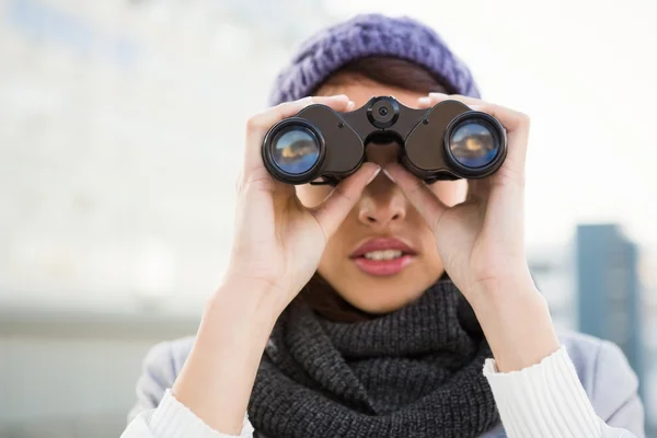 Žena s zimní oblečení při pohledu do dalekohledu — Stock fotografie