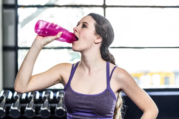 在健身球上渴女人喝水 — 图库照片