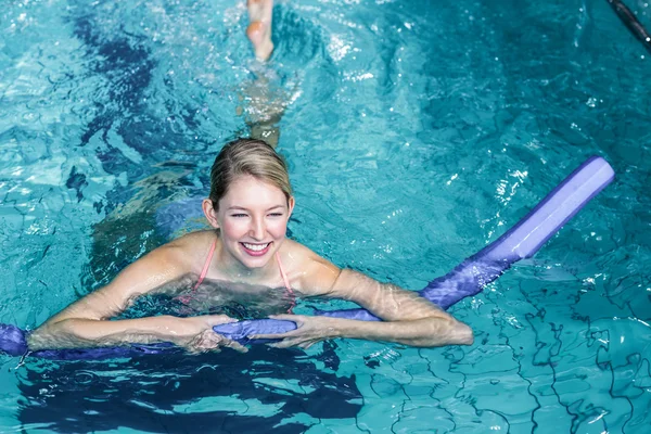 Vältränad kvinna gör vattenaerobics med skum rullar — Stockfoto