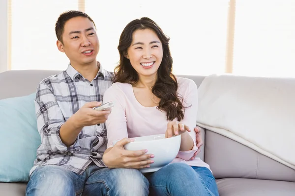 Happy couple sitting on sofa a — Stock Photo, Image