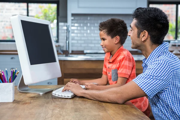 Sorrindo pai usando computador com seu filho — Fotografia de Stock