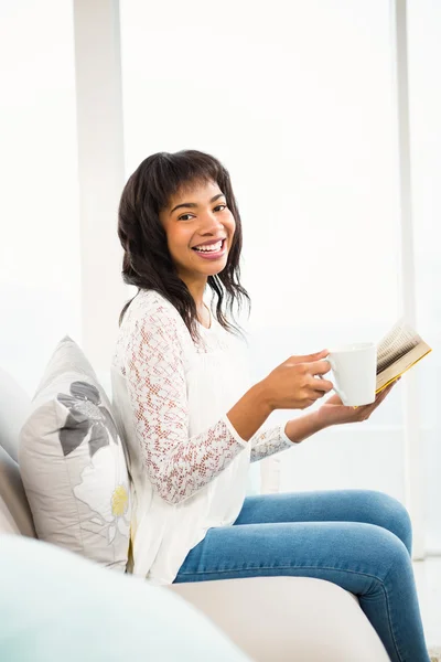 Lächelnde, lässige Frau mit Buch — Stockfoto