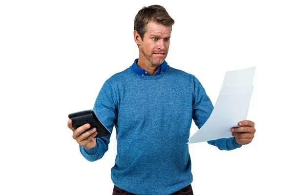 Homem chocado segurando calculadora e papel — Fotografia de Stock