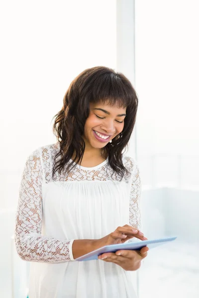 Lachende vrouw met behulp van haar tablet in woonkamer — Stockfoto