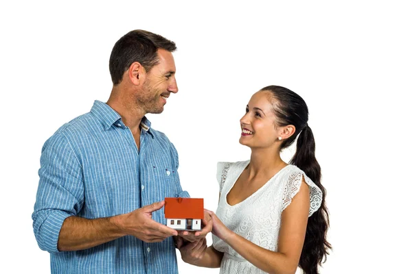 Face to face couple holding house model — Stock Photo, Image