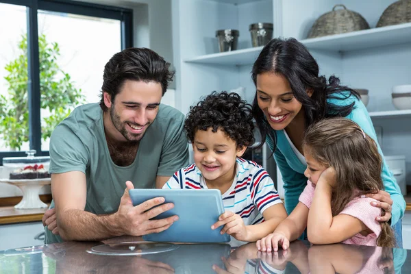 Ευτυχισμένη οικογένεια χρησιμοποιώντας tablet στην κουζίνα — Φωτογραφία Αρχείου