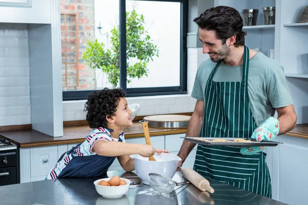 Lachende vader en zoon koken koekjes — Stockfoto