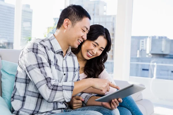 Jeune couple joyeux regardant tablette numérique — Photo