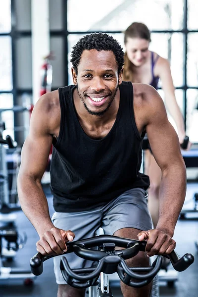 Hombre en forma haciendo ejercicio en la clase de spinning —  Fotos de Stock