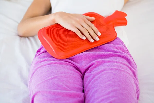 Frau liegt mit Bauchschmerzen auf ihrem Bett — Stockfoto