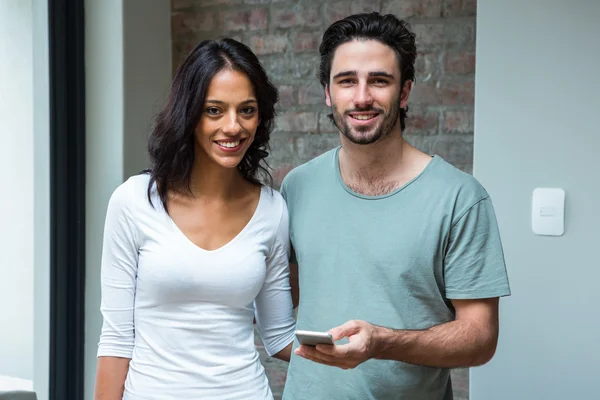 Glückliches Paar nutzt Smartphone im Wohnzimmer — Stockfoto