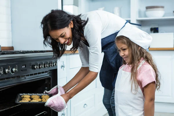 Lachende moeder zetten koekjes — Stockfoto