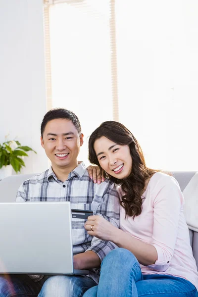 Portrait of young couple sitting on sofa — Stock Photo, Image