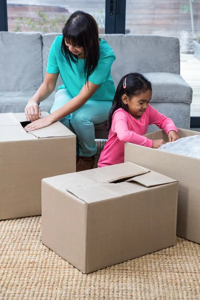 Happy mother and daughter opening boxes — Stock Photo, Image