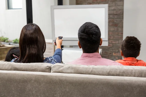 Familia feliz viendo la televisión en el sofá — Foto de Stock