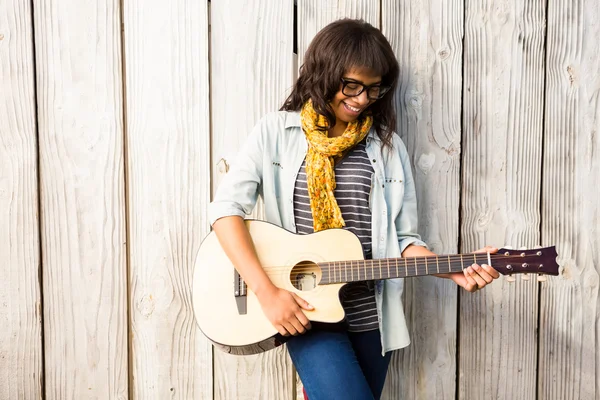 Smiling casual woman playing guitar — Stock Photo, Image