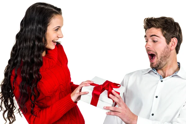 Smiling woman giving gift to her surprised boyfriend — Stock Photo, Image