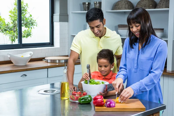 Voorbereiding van de salade in de keuken en gelukkige familie — Stockfoto