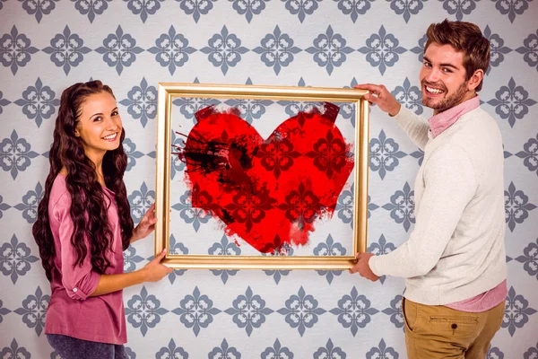Sonriente pareja sosteniendo rojo corazón forma —  Fotos de Stock