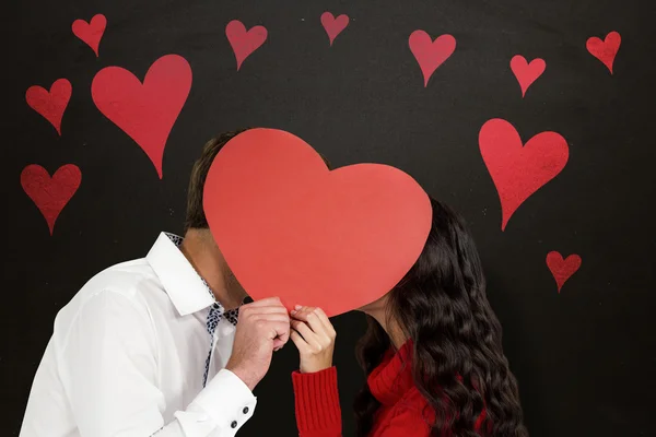 Sonriente pareja sosteniendo rojo corazón forma — Foto de Stock