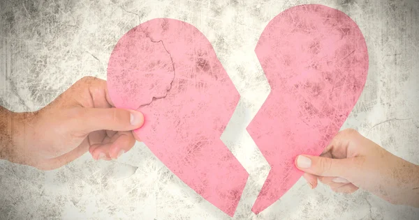 Couple holding two halves of broken heart — Stock Photo, Image