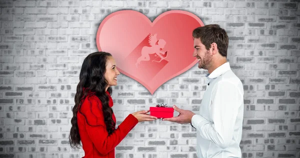 Smiling couple holding red heart shape — Stock Photo, Image