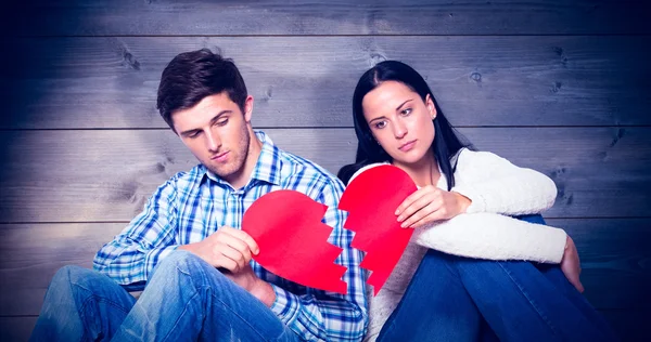 Young couple sitting on floor with broken heart — Stock Photo, Image