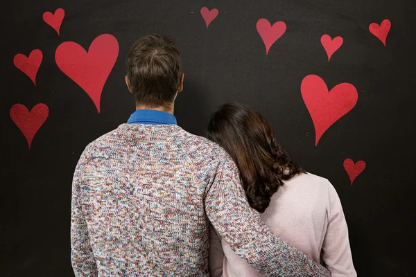 Smiling couple holding red heart shape — Stock Photo, Image