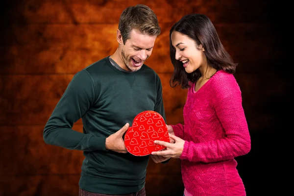 Pareja joven con regalo en forma de corazón — Foto de Stock