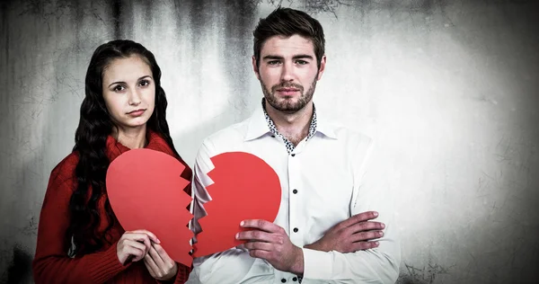 Imagen compuesta de pareja sosteniendo mitades del corazón Fotos de stock