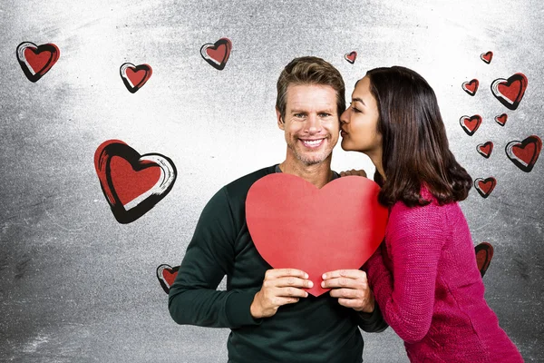 Pasangan tersenyum memegang bentuk hati merah — Stok Foto