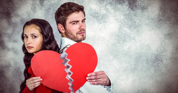 Couple back to back holding heart halves — Stock Photo, Image