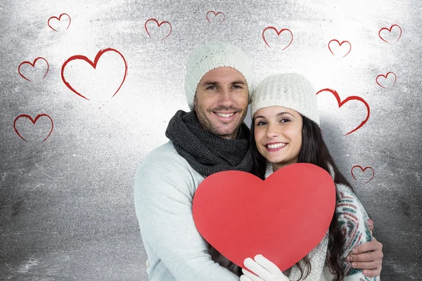 Sonriente pareja sosteniendo rojo corazón forma — Foto de Stock