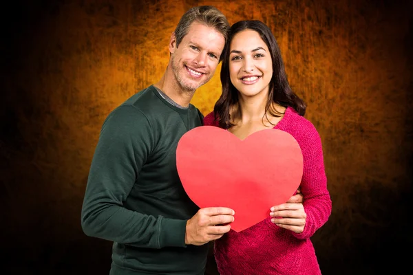 Coppia sorridente tenendo forma di cuore — Foto Stock