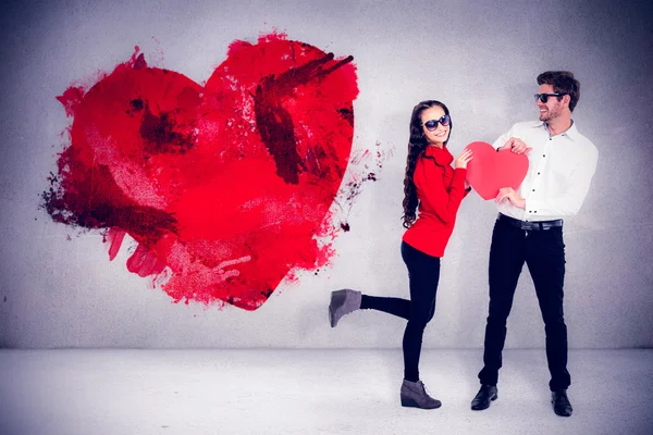 Sonriente pareja sosteniendo rojo corazón forma —  Fotos de Stock