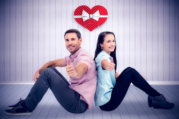 Smiling couple holding red heart shape — Stock Photo, Image