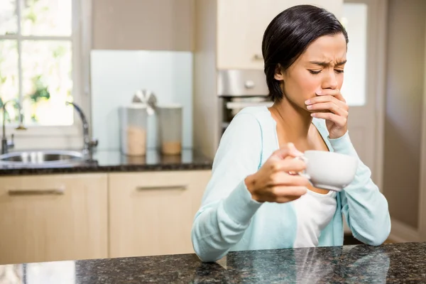 Frowning woman with toothache holding cup — Stock Photo, Image