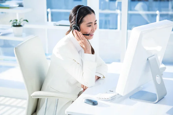 Glimlachende zakenvrouw met hoofdtelefoon werken — Stockfoto