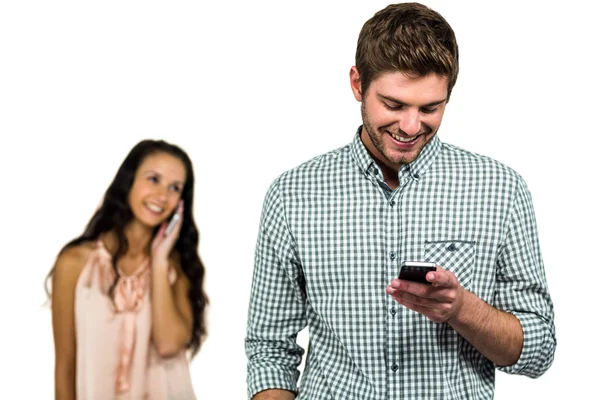 Couple souriant utilisant un smartphone — Photo