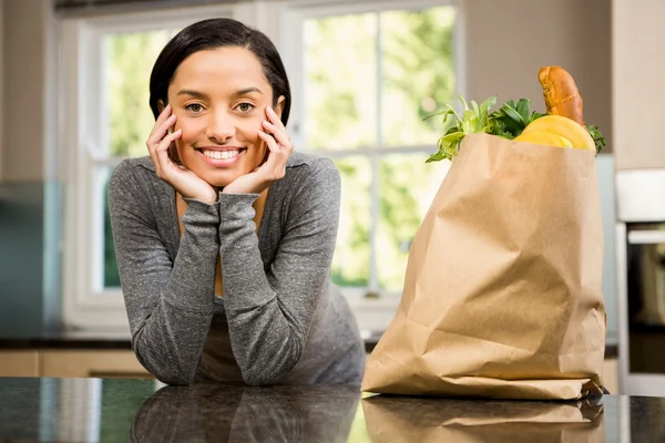 Brunette with grocery bag on counter — Stock Photo, Image