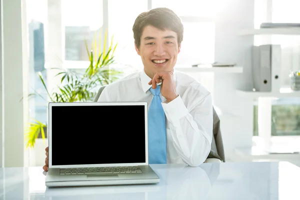 Smiling businessman showing his computer — Stock Photo, Image