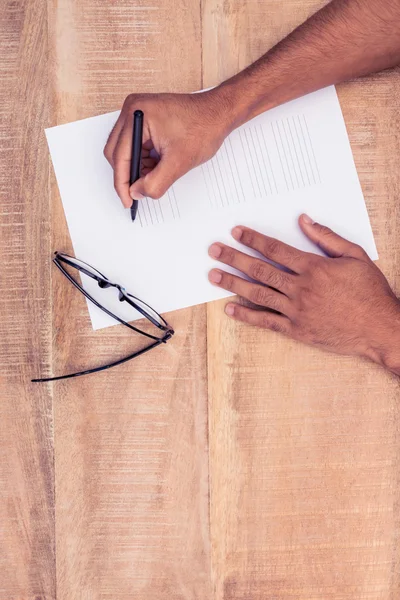 Бізнесмен пише на папері окулярами — стокове фото