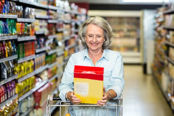 Smiling senior woman buying cereals — Stock Photo, Image